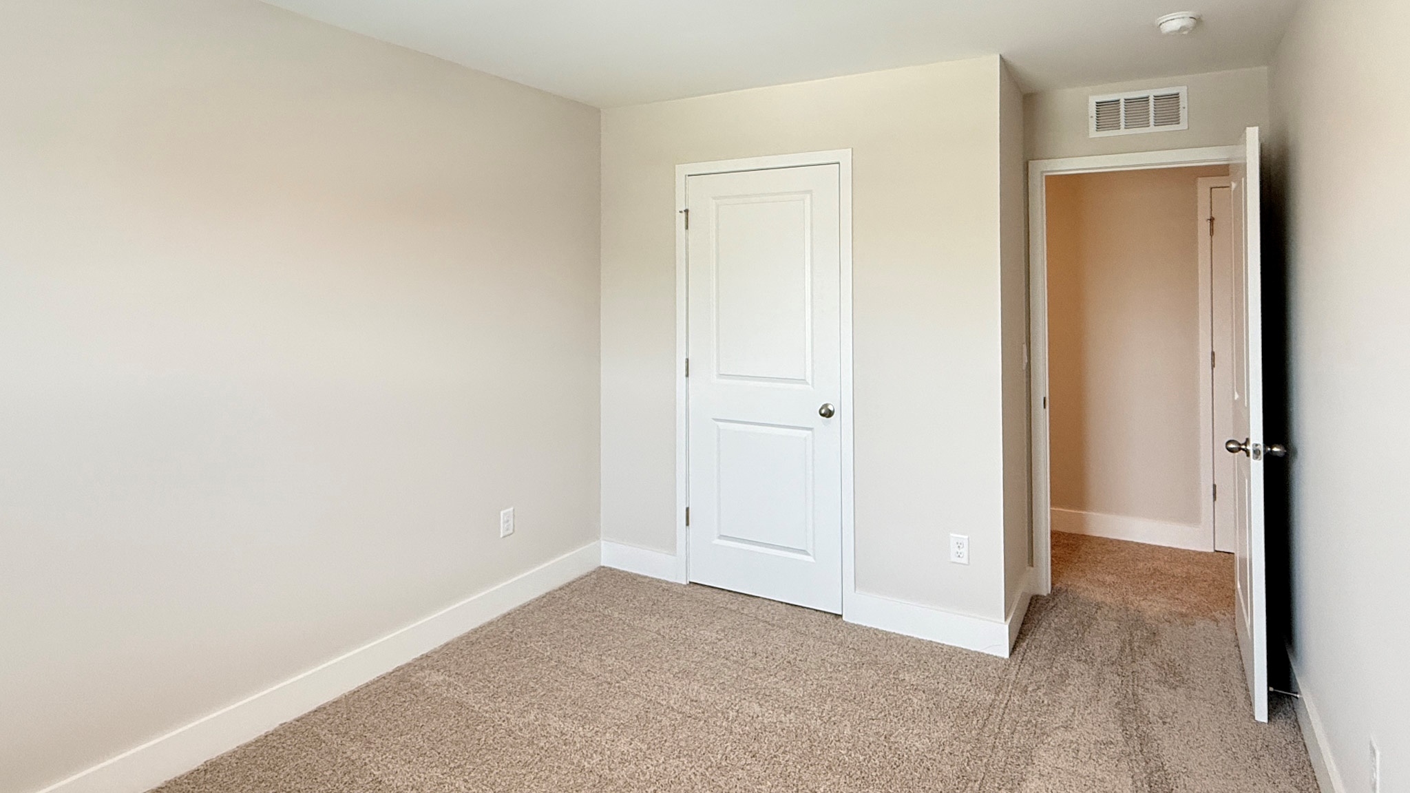Spare bedroom with closet and bedroom entry door.