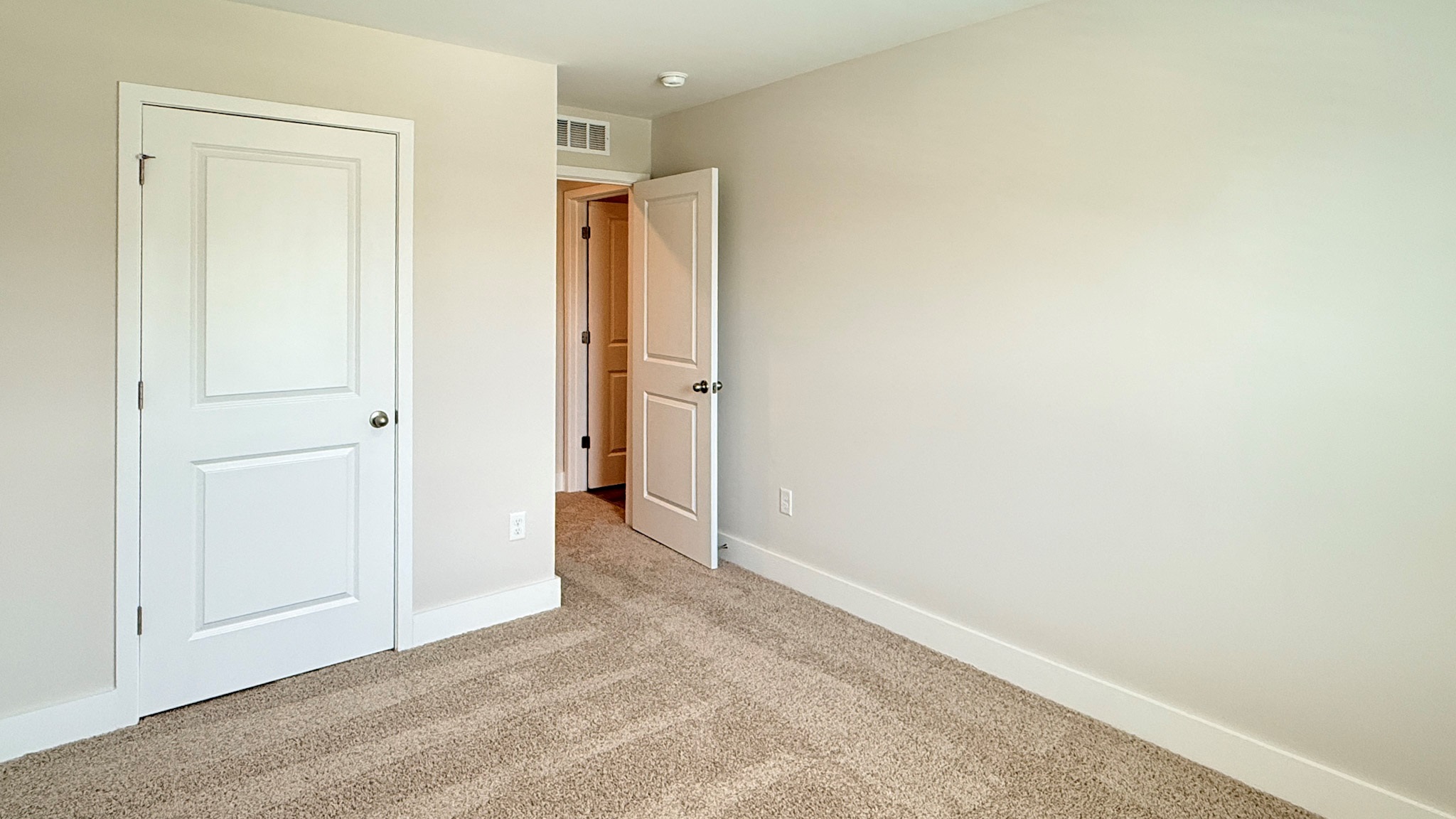 Spare bedroom with closet and bedroom entry door.