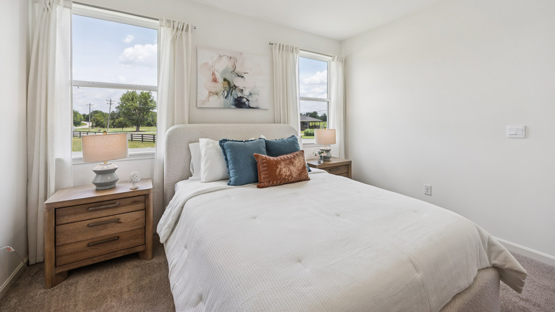 primary bedroom with king size bed, two night stands and windows