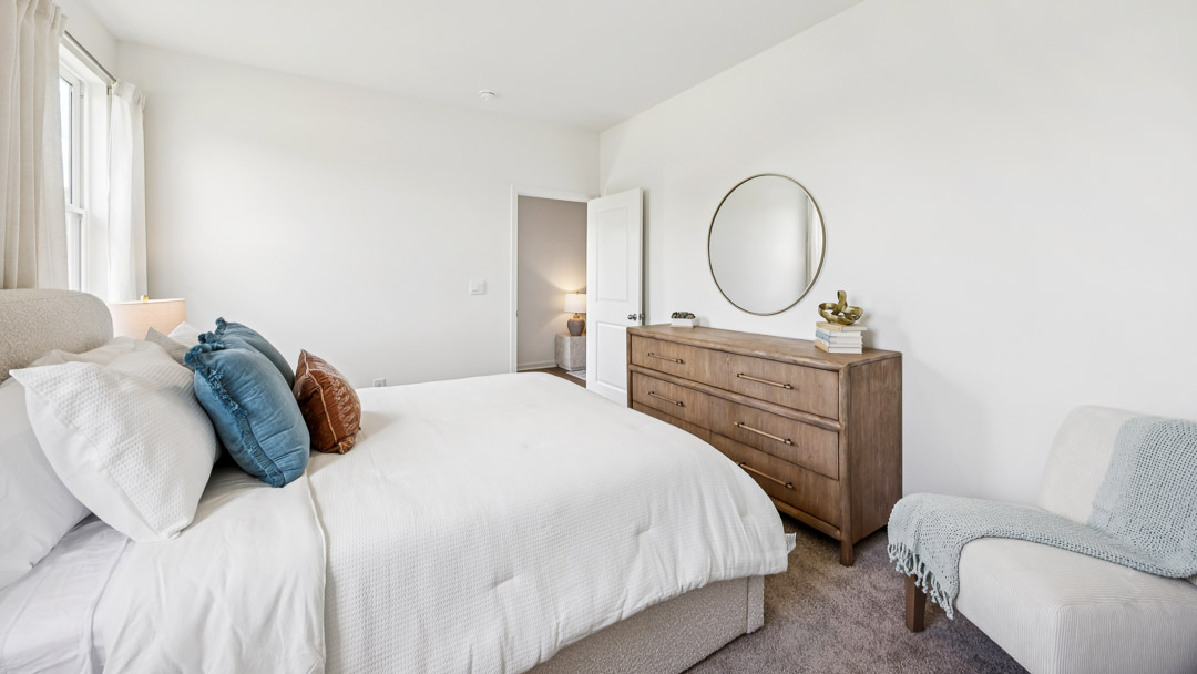 primary bedroom with king size bed and accent chair