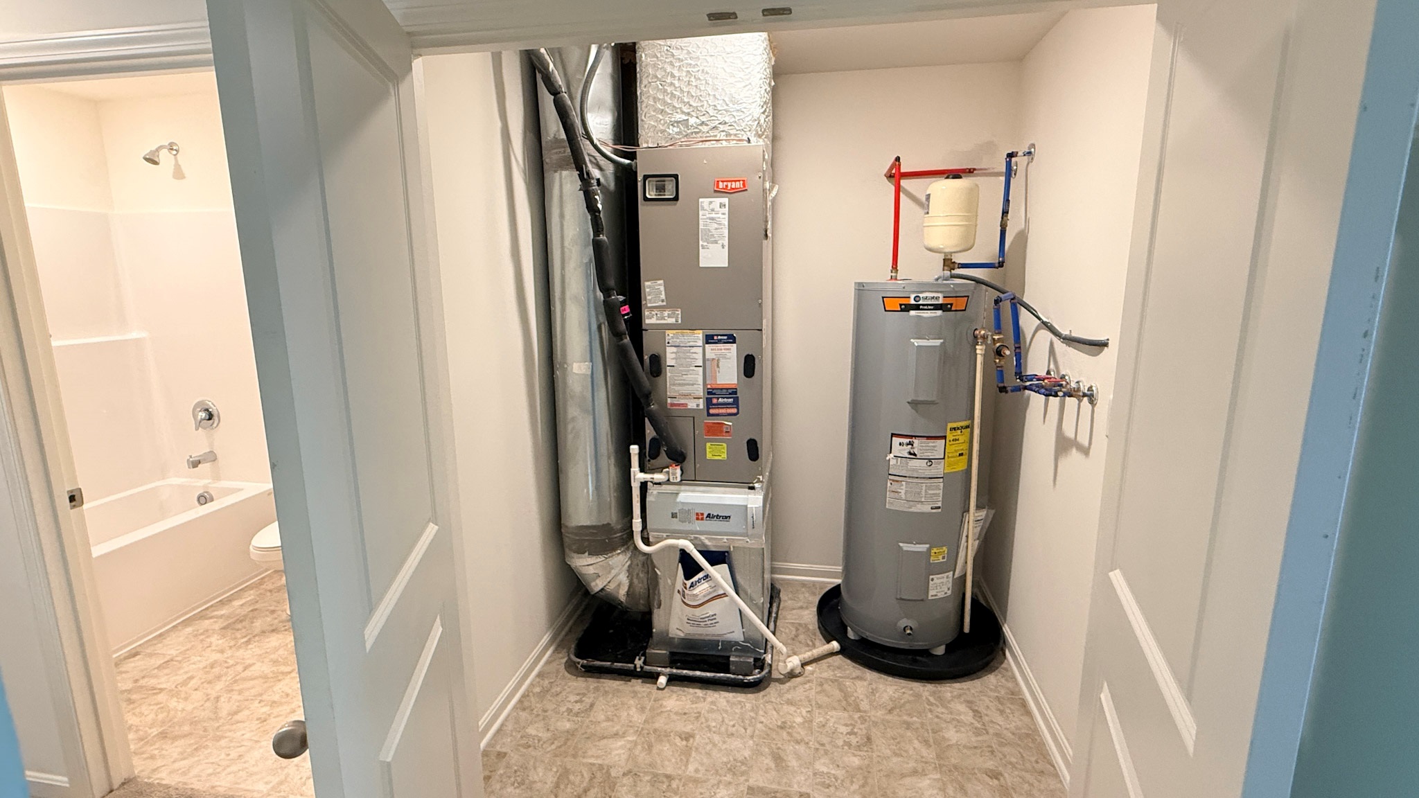 Second floor mechanical room with furnace and water heater.