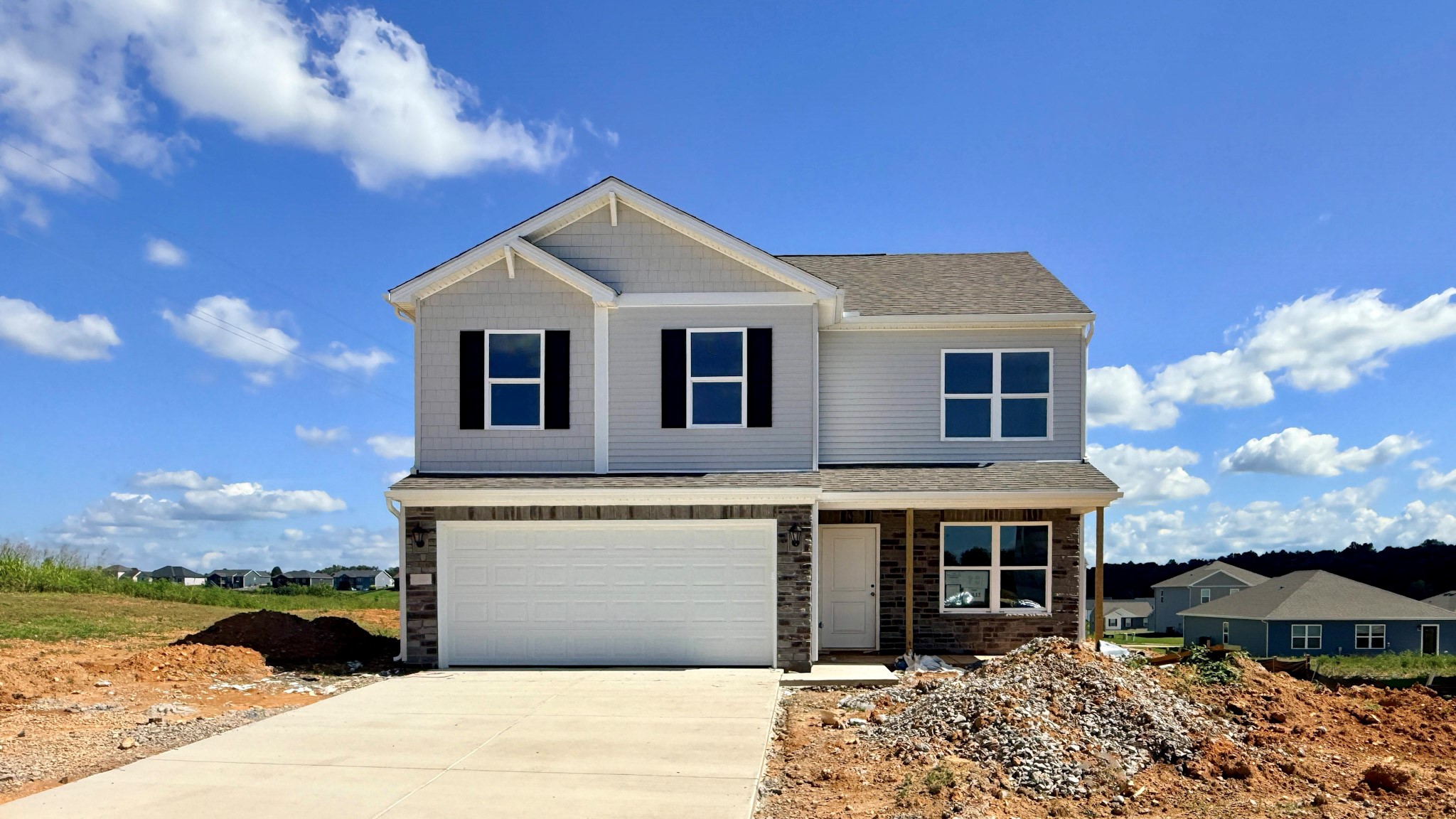 Quick move-in Bellamy floor plan in Cowley Farms of Elizabethtown, Kentucky with a gray siding, stone accents, a covered front porch, and a 2-car attached garage.