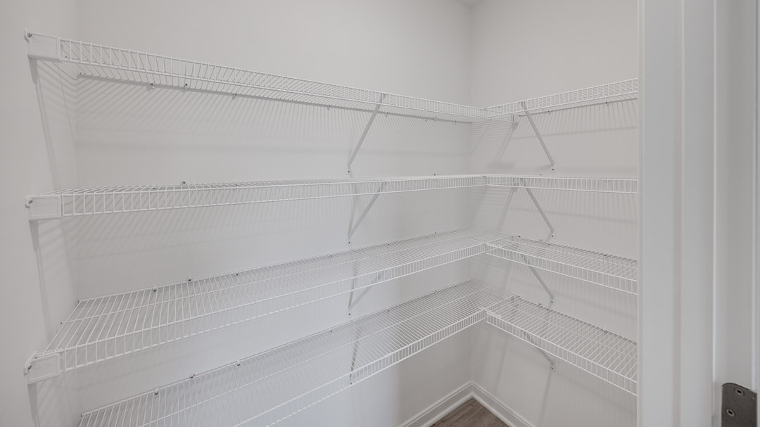 Walk-in pantry with four rows of wire shelving.