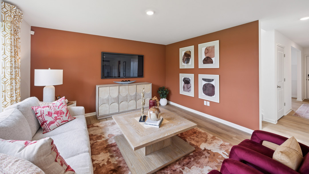 Other view of living room with tv stand, view looking into the foyer, couch, coffee table, 2 accent chairs, and endtable.