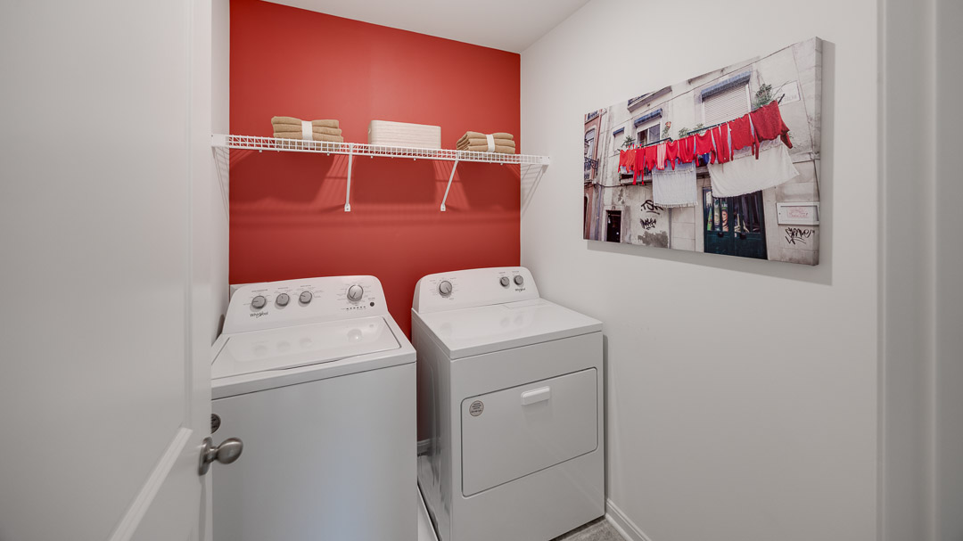Upstairs laundry room with wire shelving above the washer and dryer.