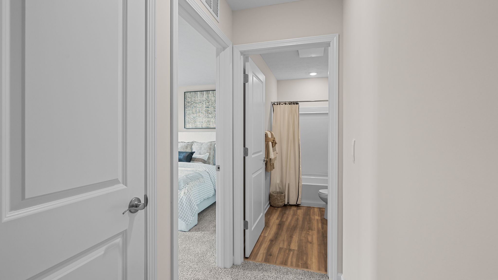 Second floor hallway facing a spare bedroom entry door and spare bathroom entry door.