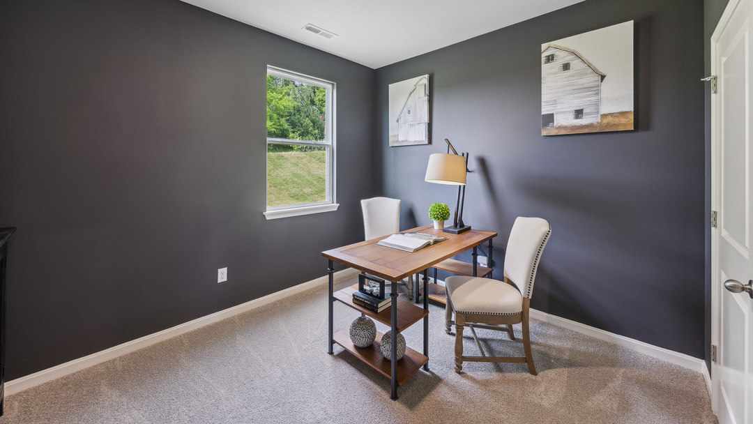 First floor spare bedroom decorated as second home office. Single window overlooking back yard. Table and 2 chairs.