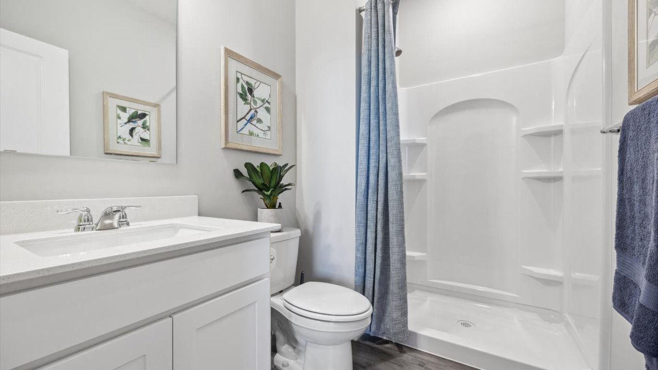 First floor full bathroom with vanity, commode, and walk-in shower.