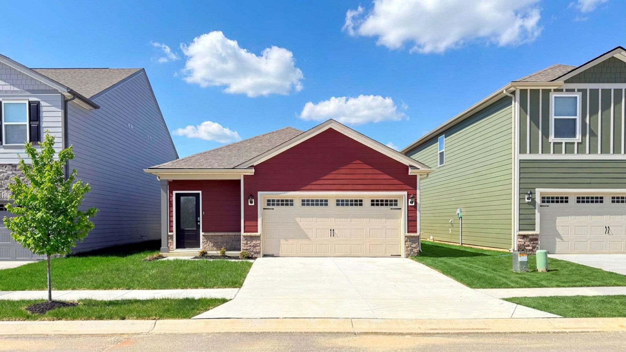 Downing floorplan with covered front porch and 2-car attached garage. Stone accents on the front of the house.
