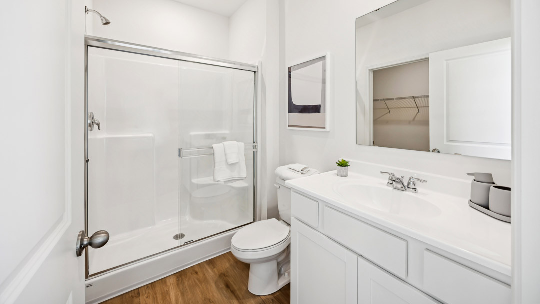 Primary bathroom with large sink vanity, commode, and walk-in shower