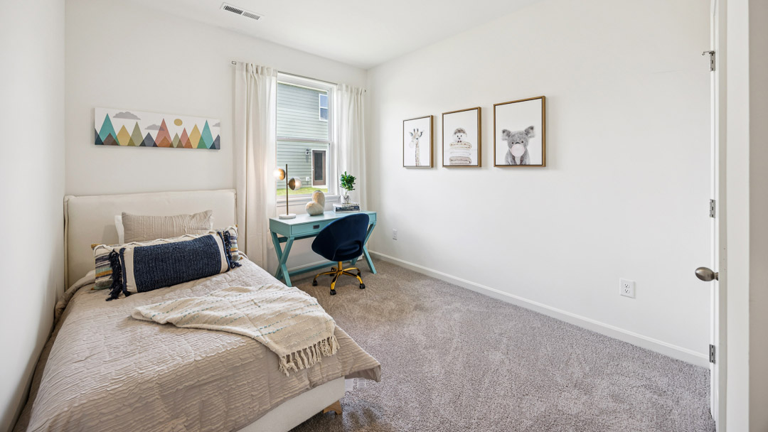 Spare bedroom with bed and small office desk/chair in front of single window