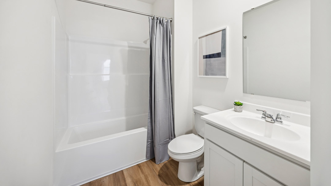 Hall bathroom with vanity, commode, and shower/tub combo