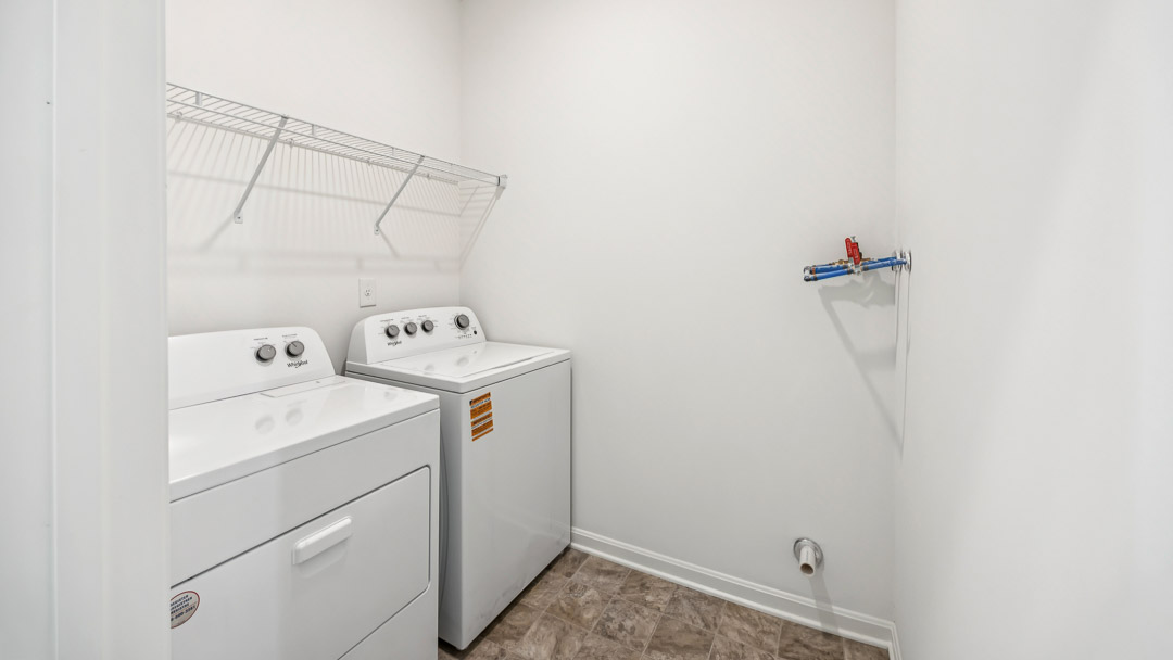 Laundry room with wire shelving above the washer and dryer