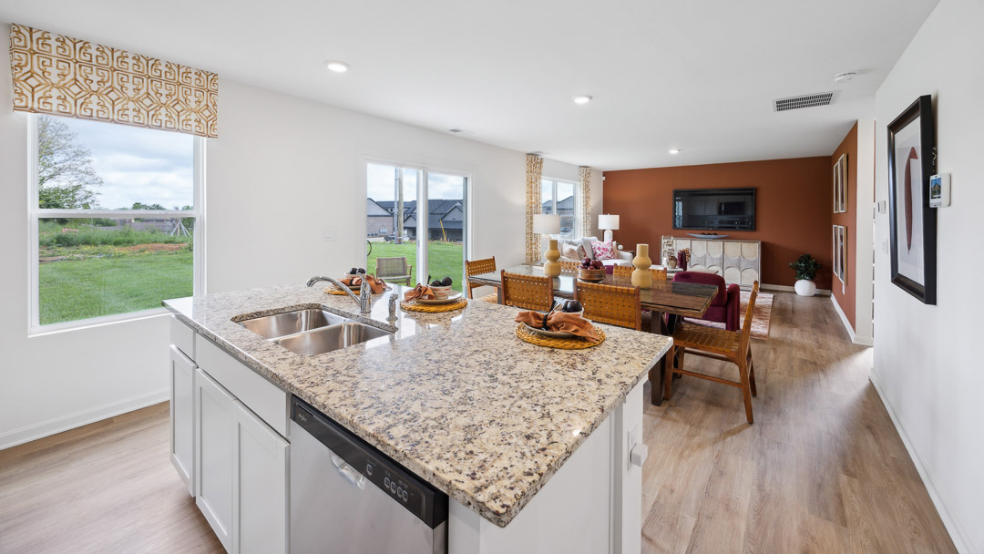 Kitchen island with built-in sink and dishwasher overlooking the dining area.
