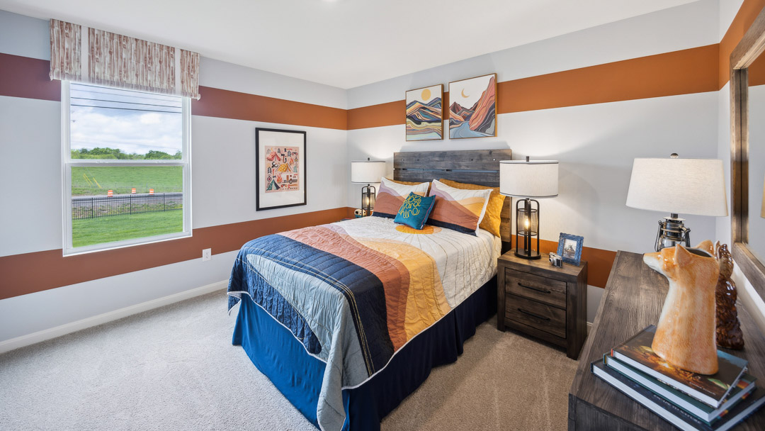 Spare bedroom with single window, bed, two nightstands with lamps, and a dresser.