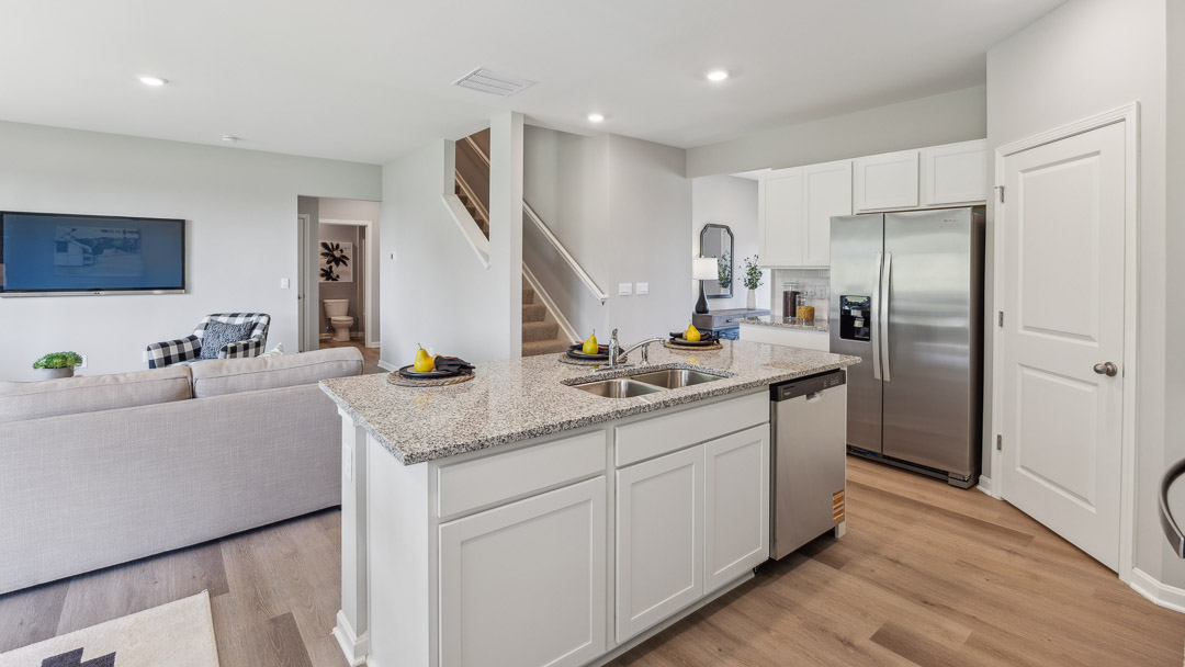 Kitchen island with built-in sink and dishwasher overlooking the living room.