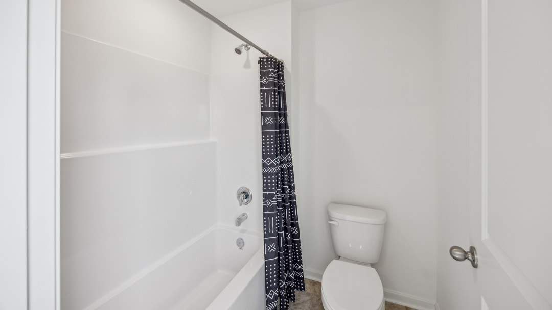 Spare bathroom with commode and shower/tub combo.