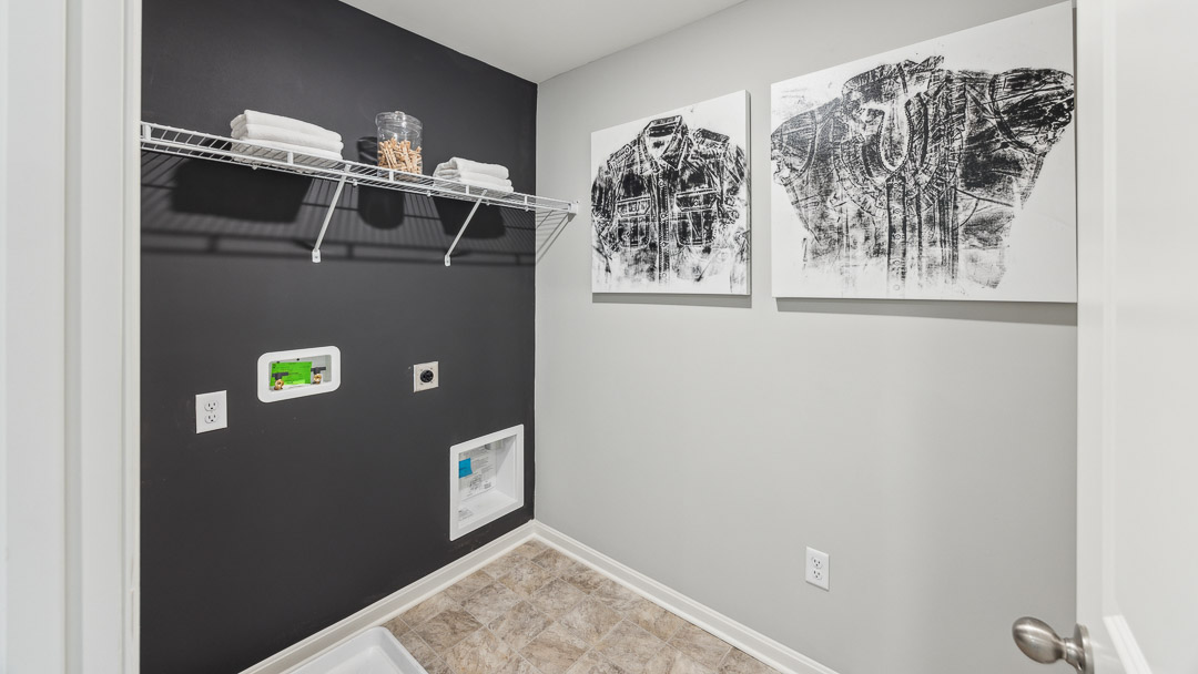 Second floor laundry room with wire shelving above the washer and dryer.