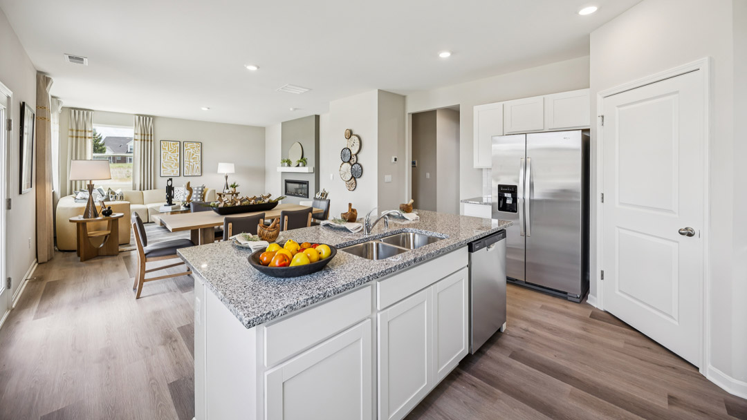 View facing over kitchen island and into the dining area and living room.