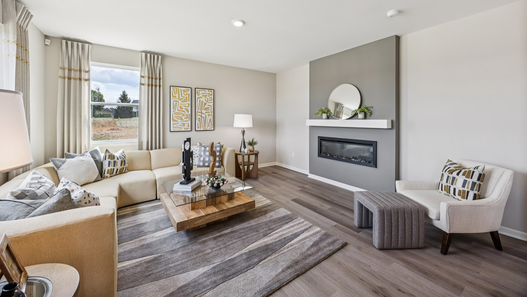 Living room featuring a built-in electric fireplace, sectional sofa, coffee table, accent chair.
