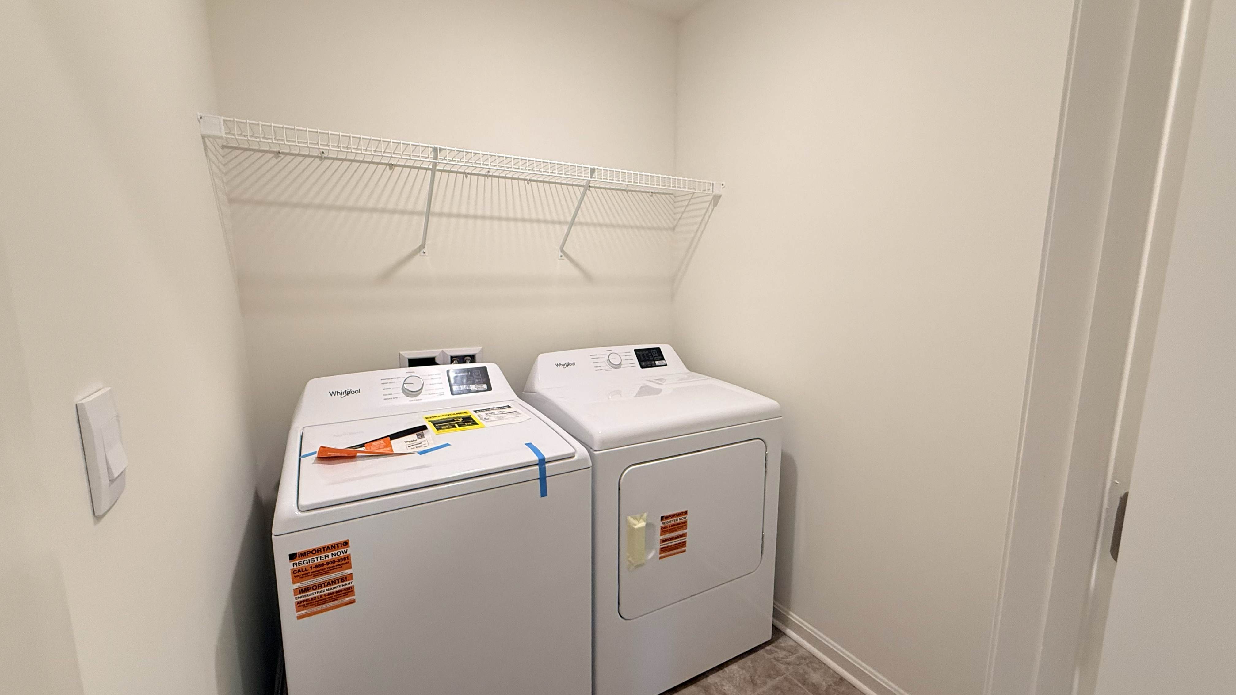 Laundry room with wire shelf above the washer and dryer.
