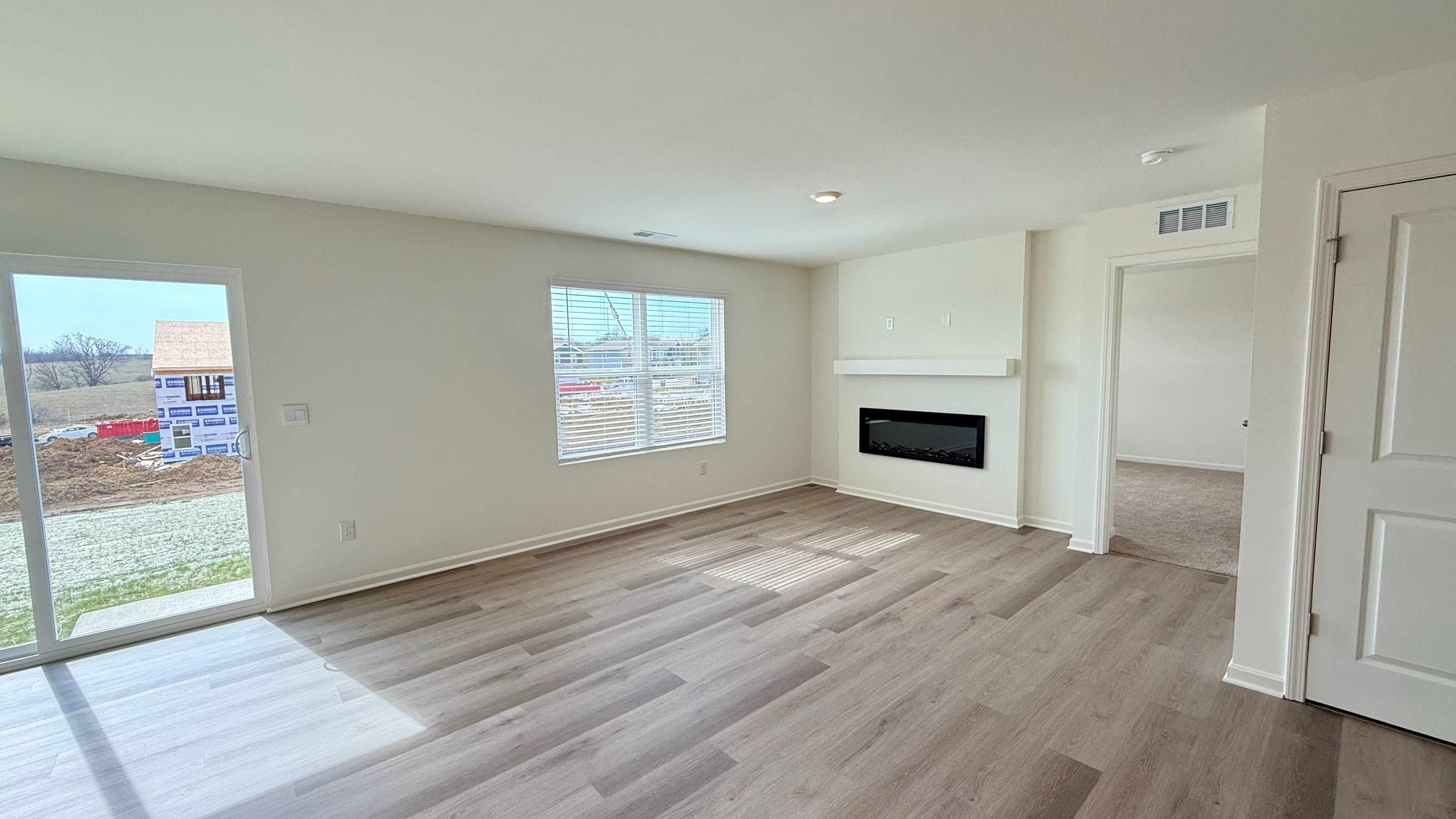 Other view of living room with double window and built-in electric fireplace.