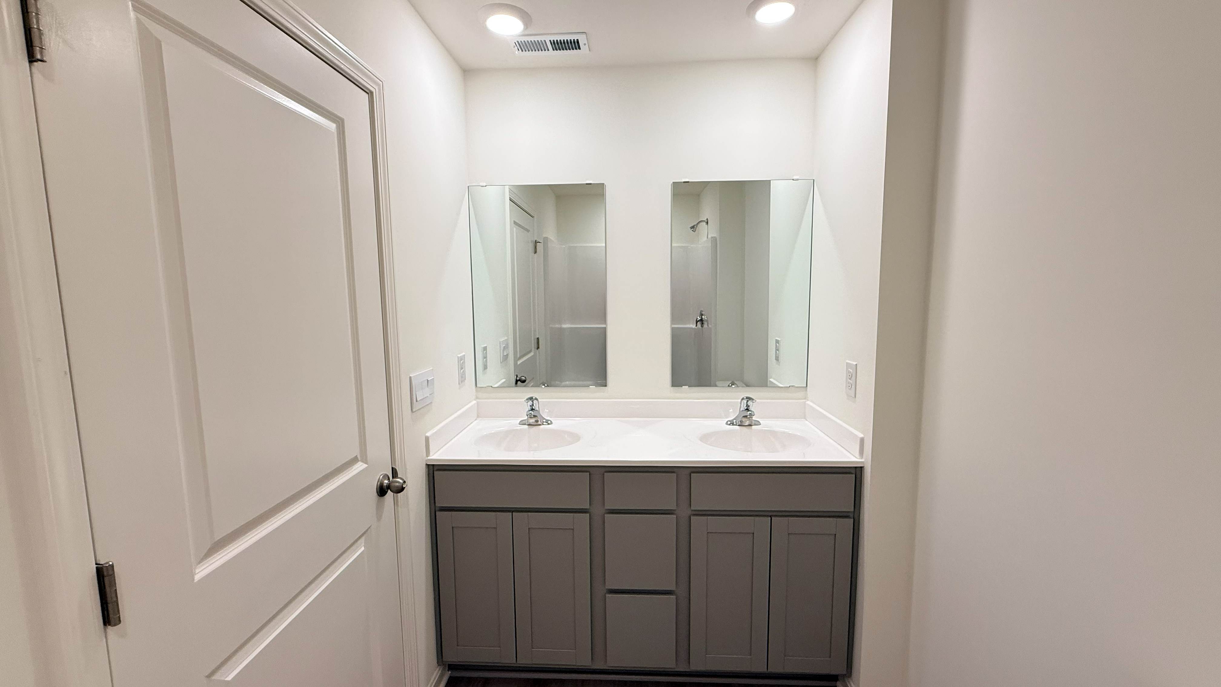 Primary bathroom with stone-gray double bowl vanity.