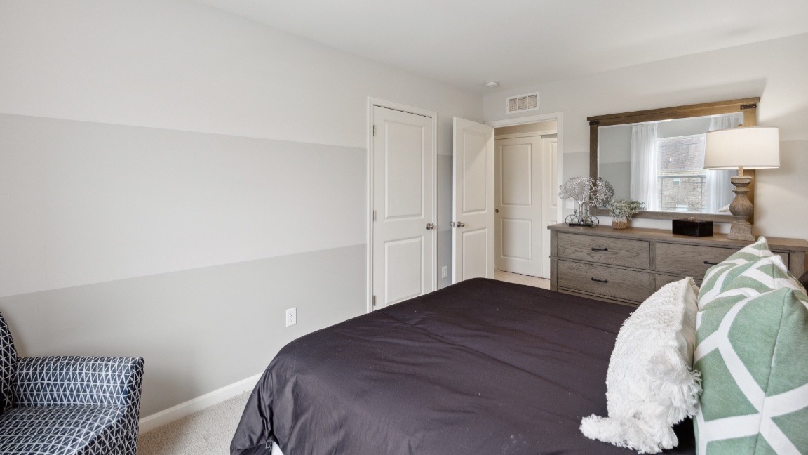 Bedroom with closet and carpeted floors.