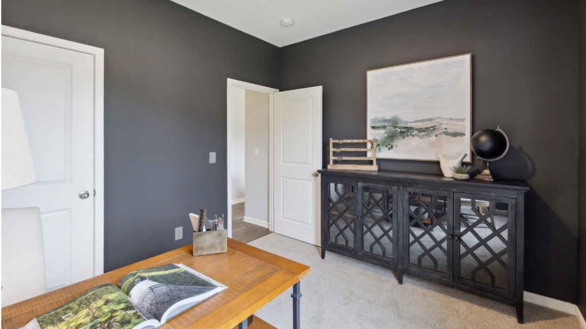 Bedroom with dark walls and carpeted floors.
