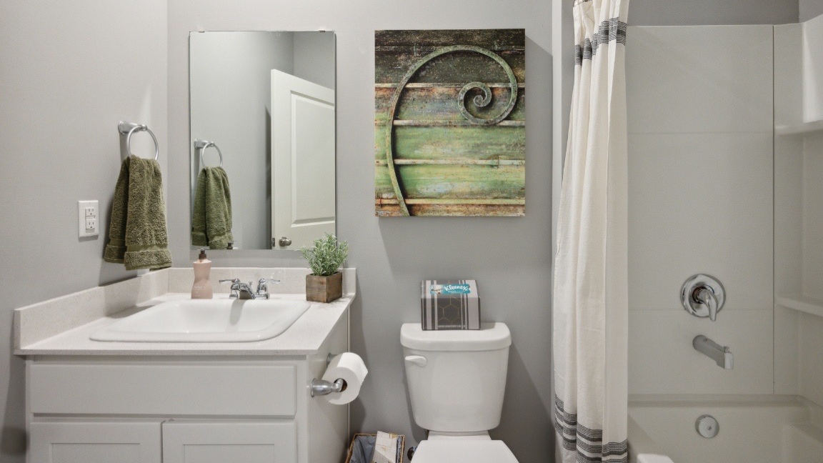 Bathroom with single sink and step in shower.
