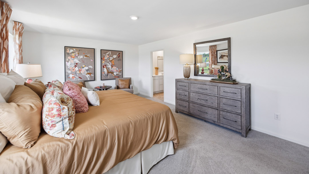 Other view of  primary bedroom with dresser and bed.