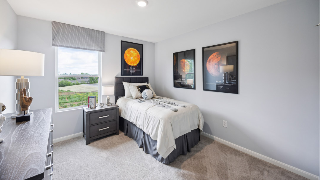 Upstairs spare bedroom with a bed, nightstand, single window, and a dresser. Solar system theme.