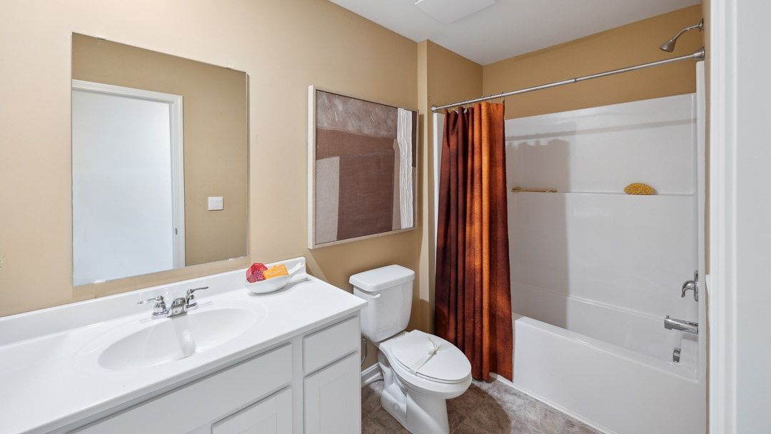 Upstairs hall bathroom with a vanity, commode, and shower/tub combo.
