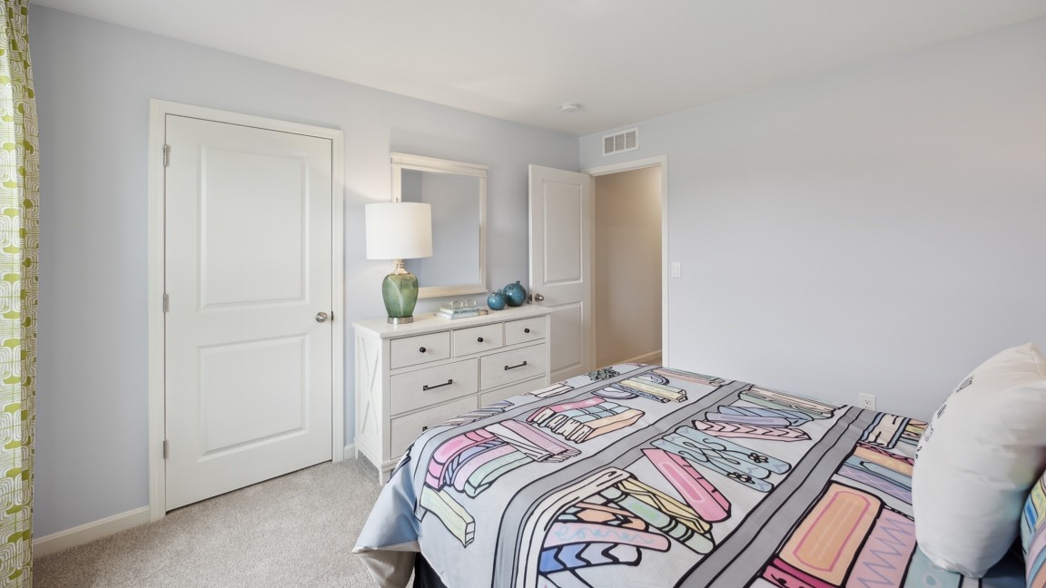 Upstairs spare bedroom with bed, closet door, and tv dresser
