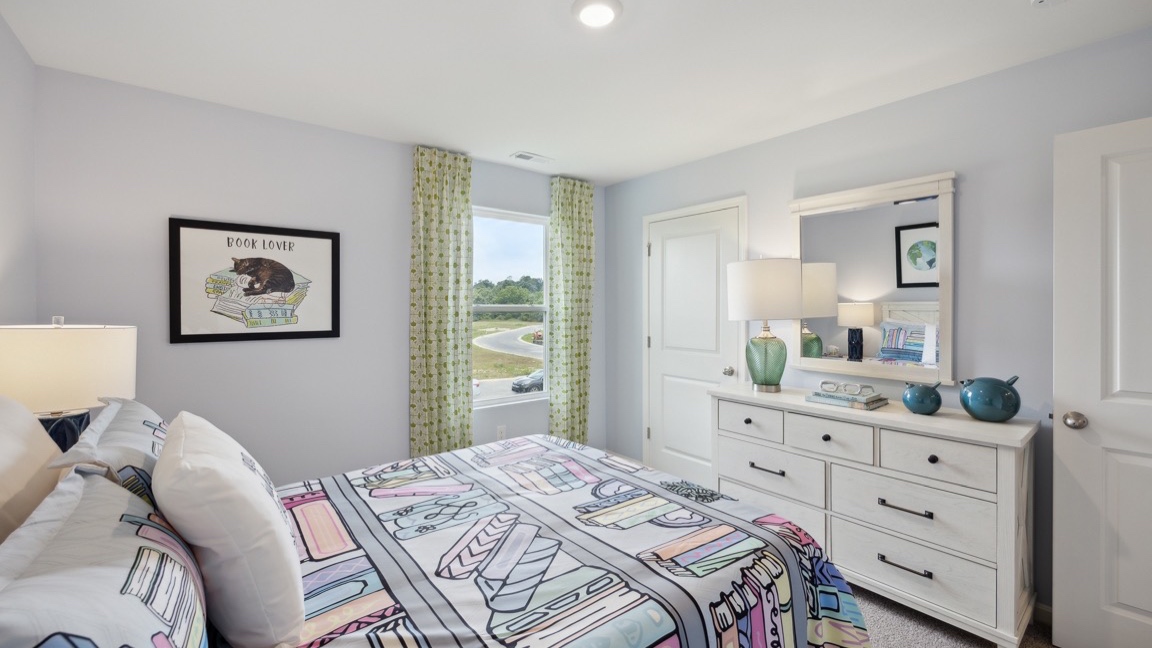Upstairs spare bedroom with bed, dresser, and single window