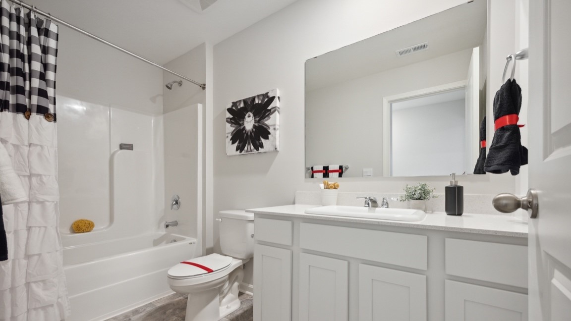 Upstairs hall bathroom with large single bowl vanity, commode, and shower/tub combo