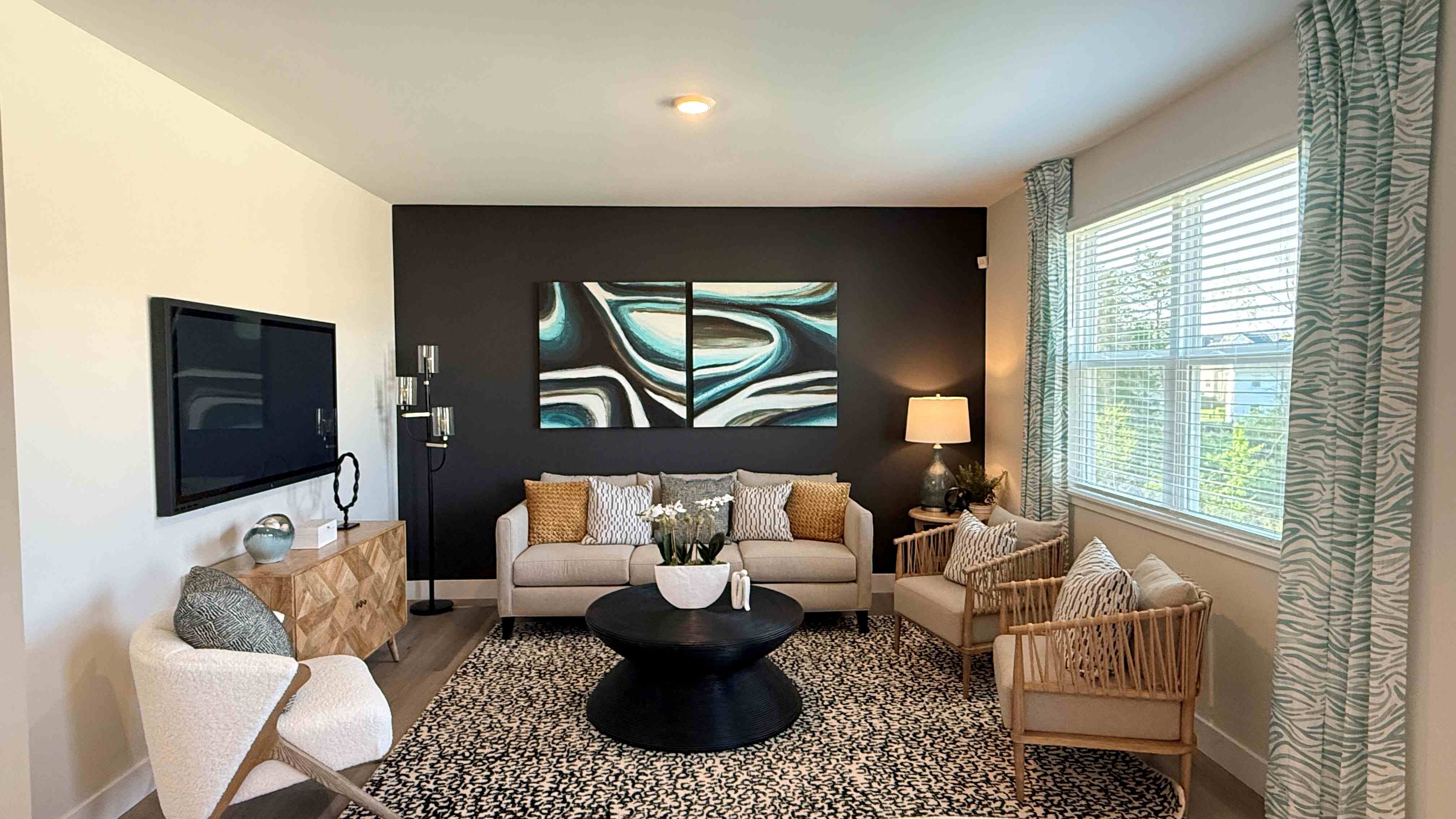 Living room with double window, couch, three accent chairs, wall-mount tv, coffee table, rug, and LVP flooring
