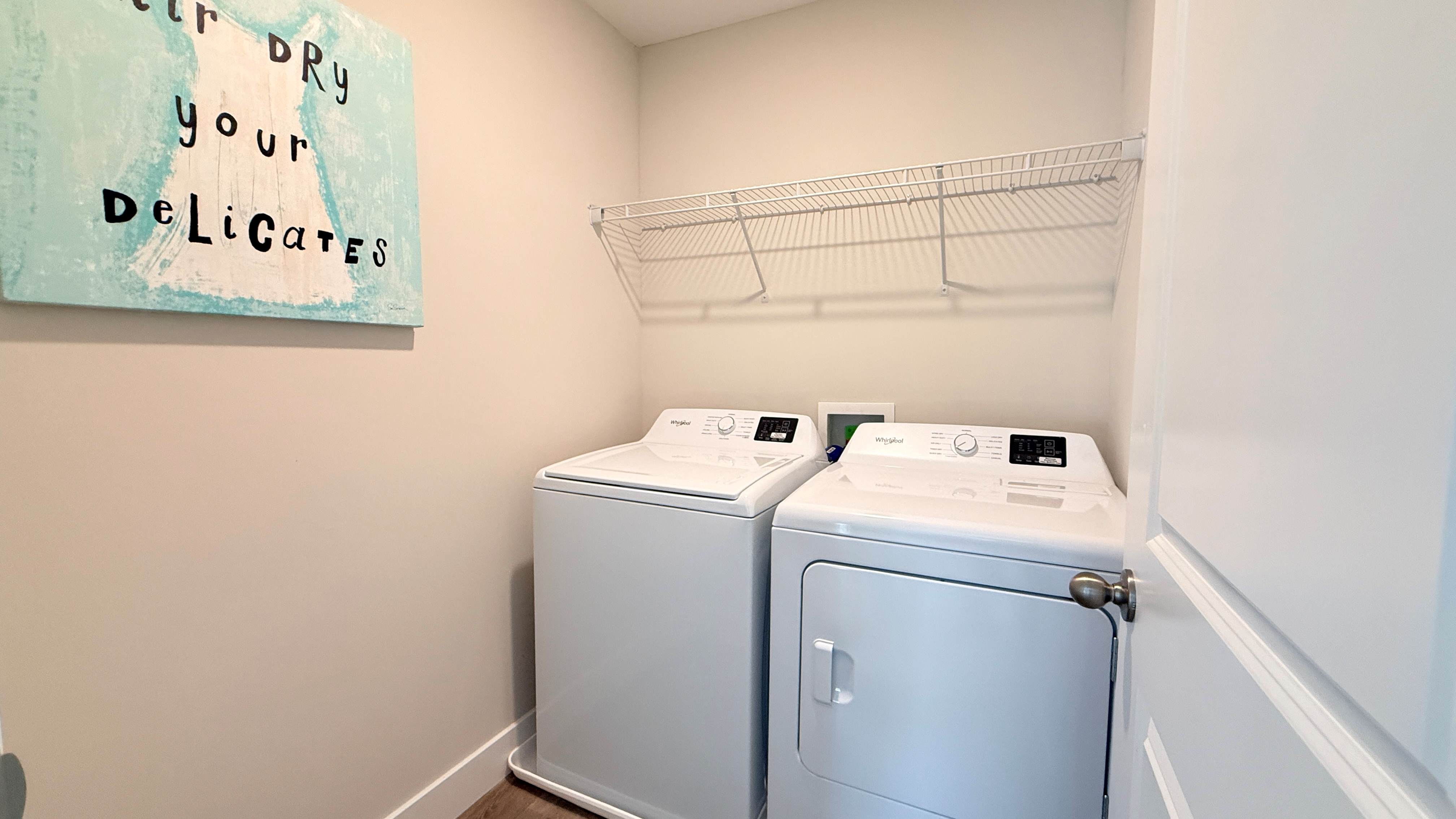 Second floor laundry room with wire shelf above the washer and dryer.