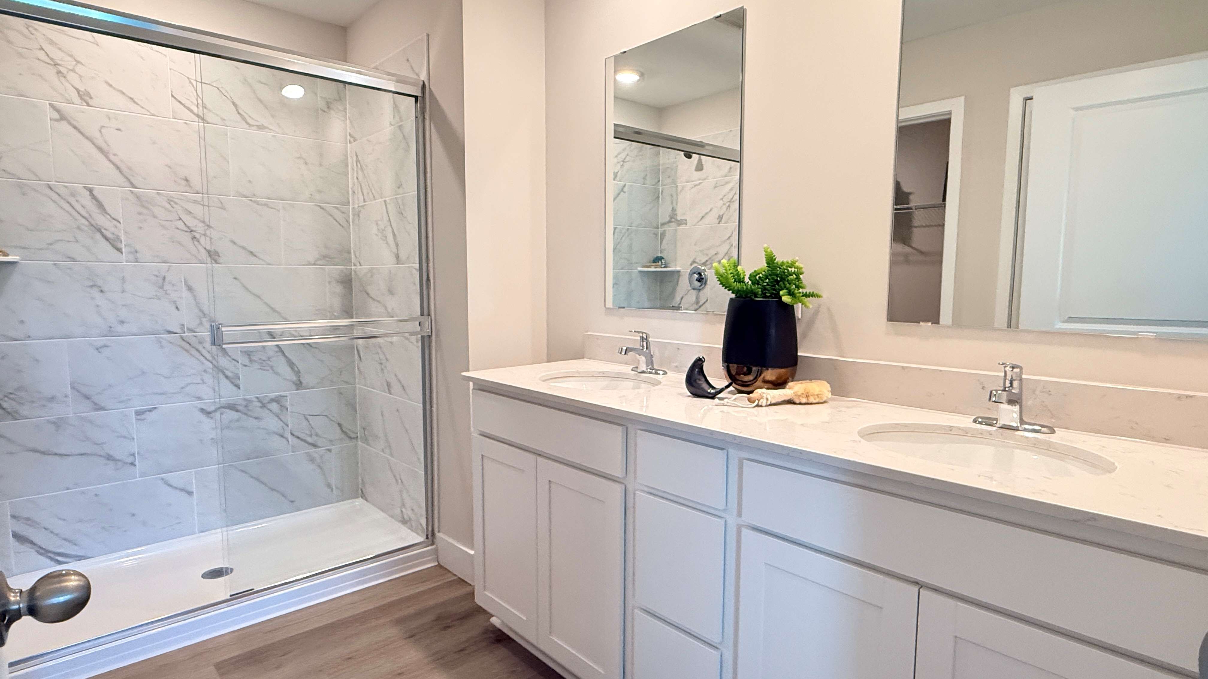 Ensuite primary bathroom with double bowl vanity and tiled walk-in shower.