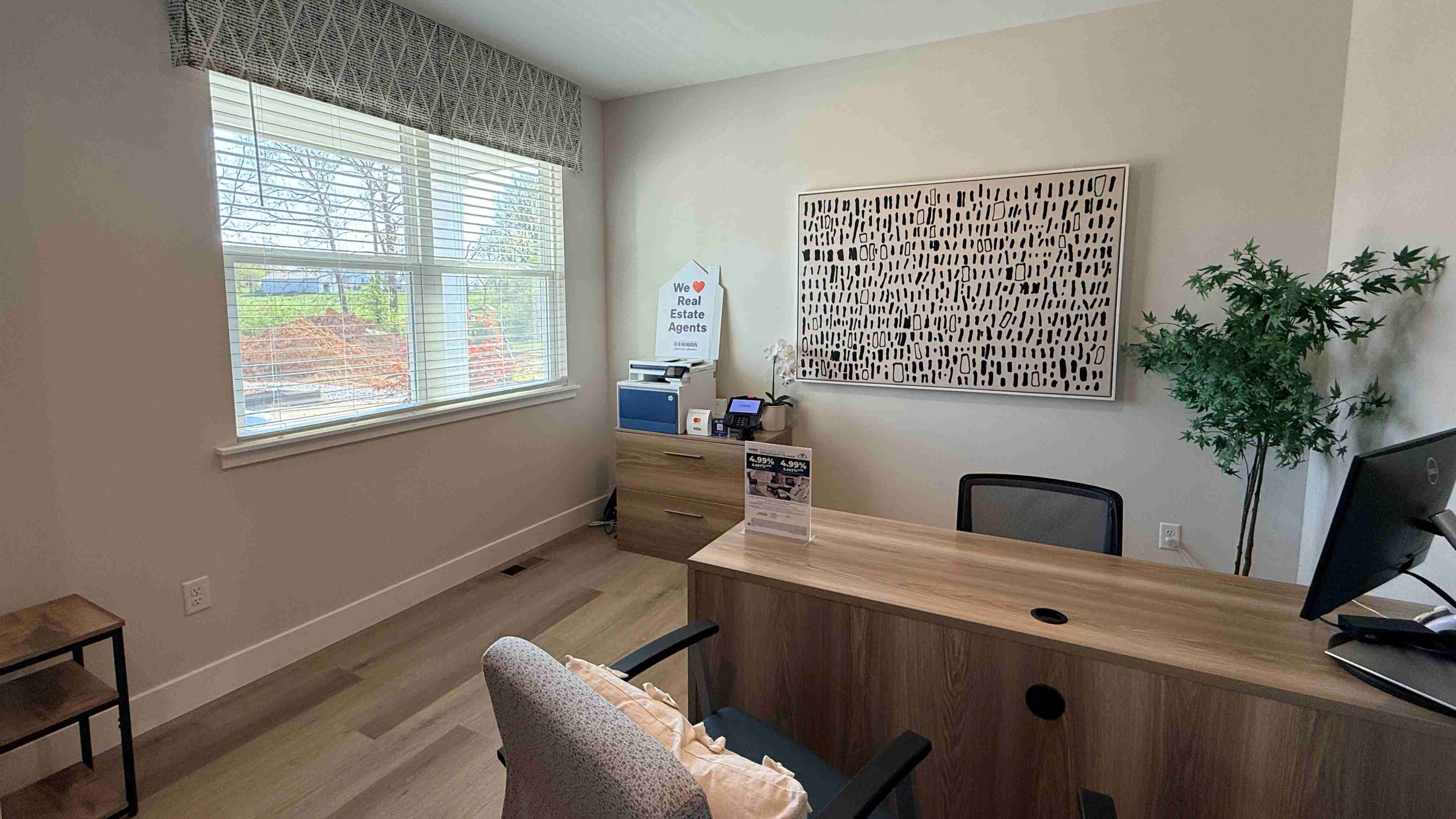 First floor flex room decorated as a home office with double window overlooking the front yard.