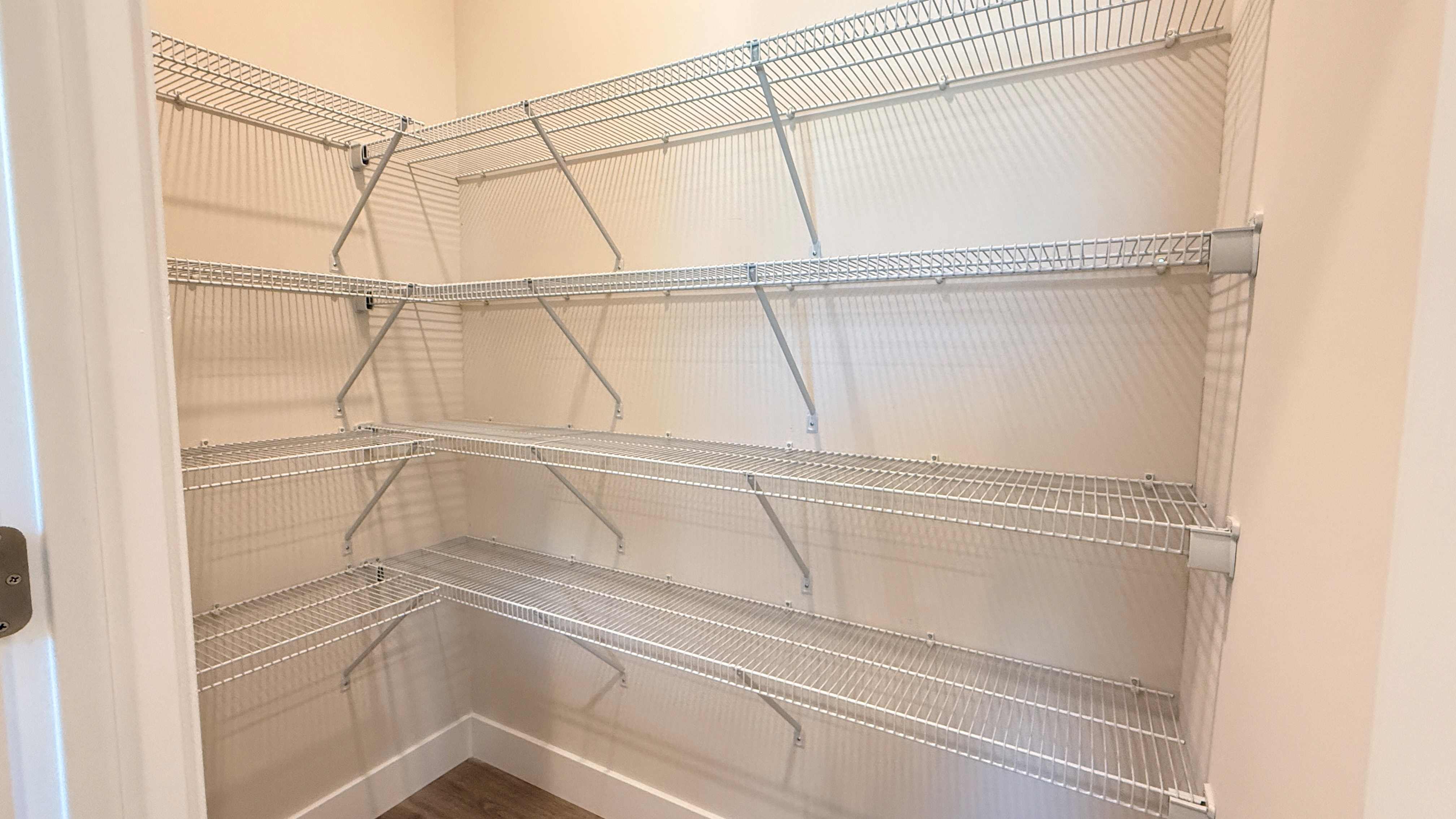 Walk-in kitchen pantry with wire shelving.