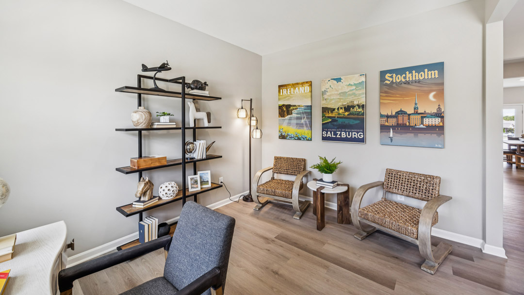 Other view of first floor flex room with bookcase and 2 accent chairs.