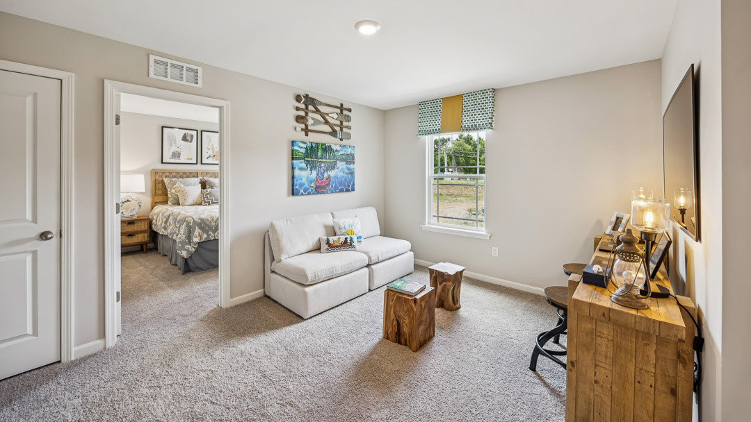 Upstairs loft area with tv, loveseat, and single window.