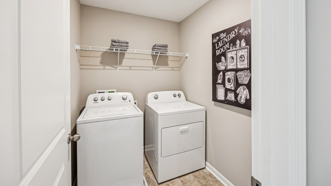 Upstairs laundry room with wire shelf above the washer and dryer.