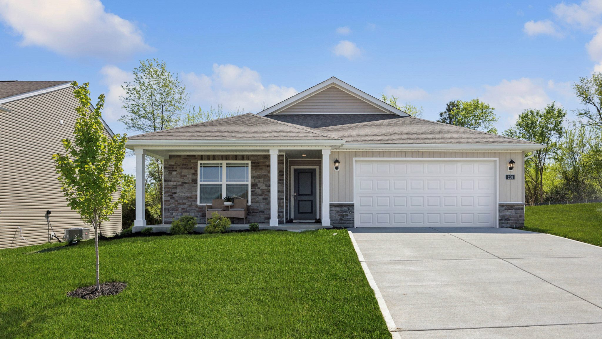 Harmony floor plan with stone front accents, a covered front porch, and a 2-car attached garage. Built by D.R. Horton Homes in Arbor View, Eminence, Kentucky.