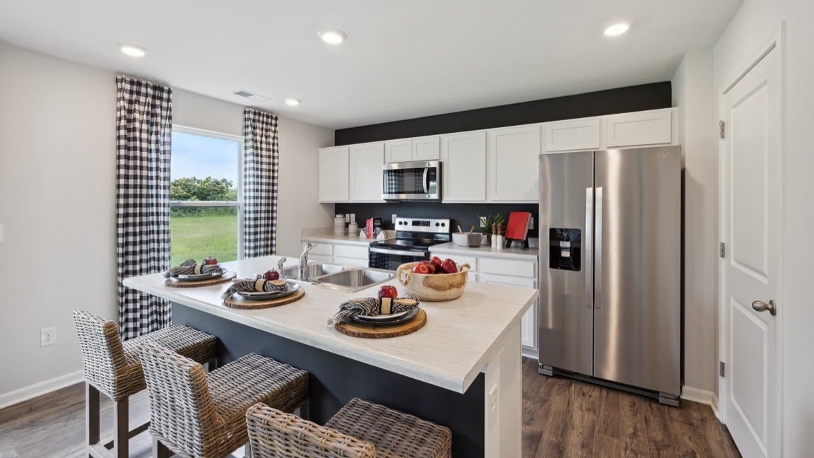 Spacious kitchen with white cabinets, laminate countertops, and stainless-steel appliances.
