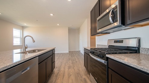 Kitchen with island seating, stainless appliances, plenty of countertop space and storage