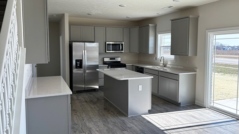 Kitchen with gray cabinets and quartz countertops