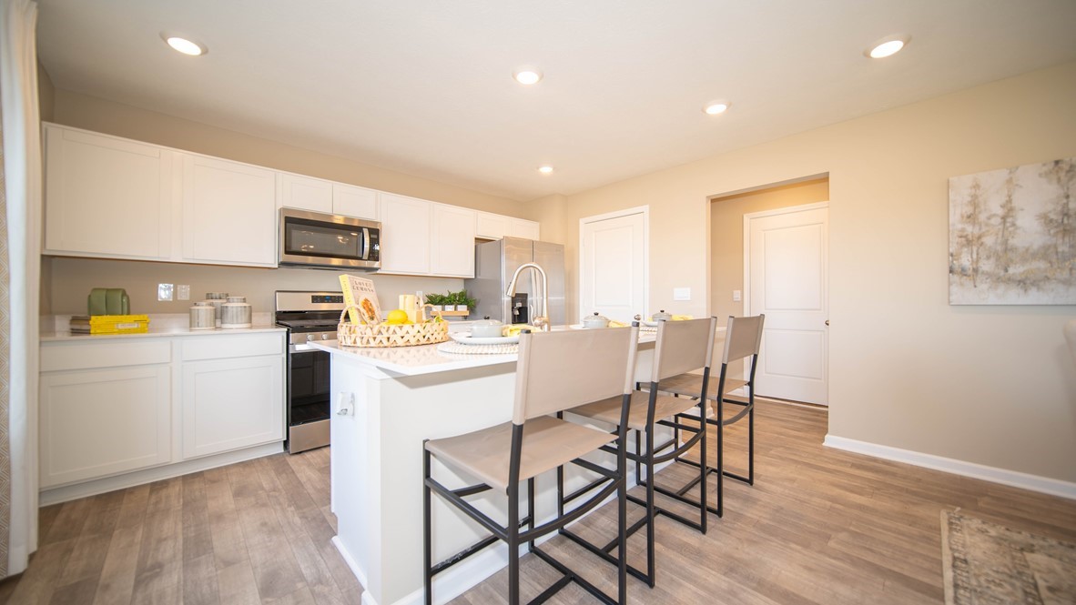 kitchen with bar seating natural light and quartz countertops