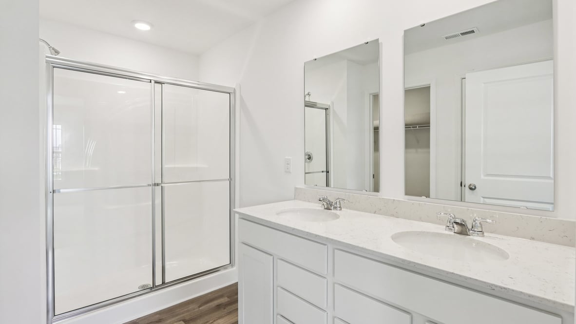 primary bathroom with double vanity and walk-in shower